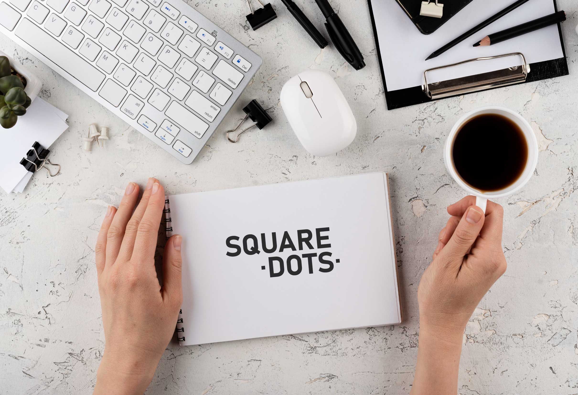 Square Dots Graphic Designer sitting at DEsk Designing